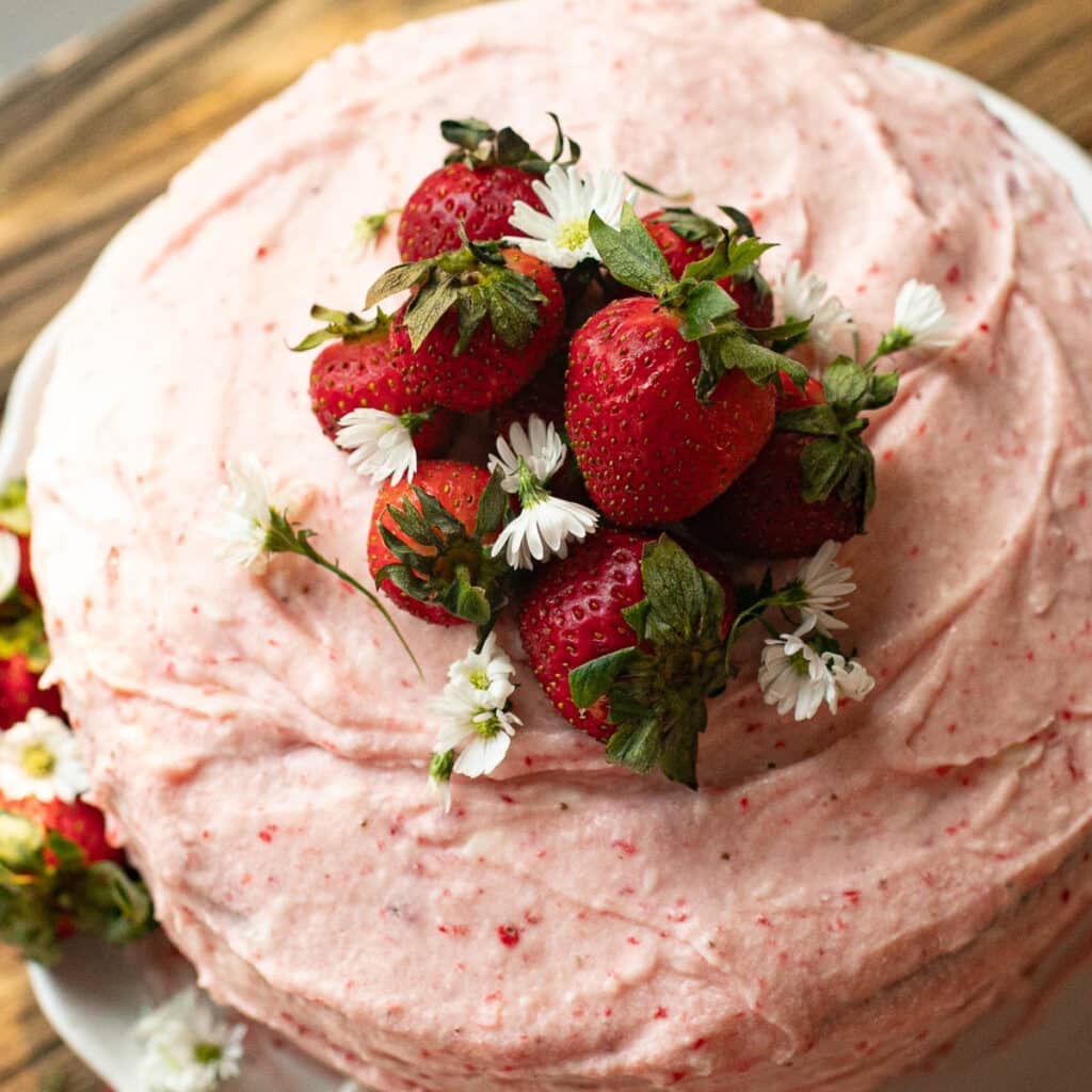 overhead view of strawberry cake with strawberry filling garnished with fresh strawberries