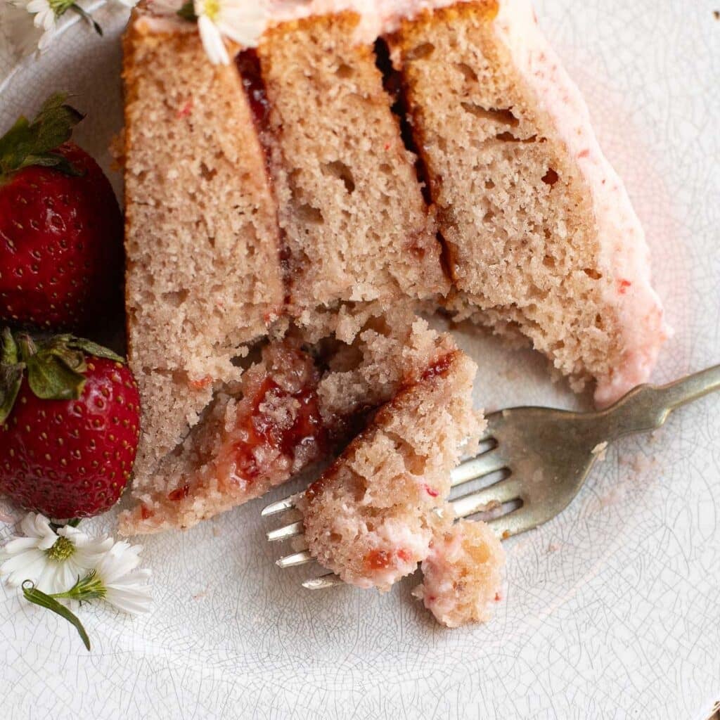 a slice of strawberry cake with strawberry filling
