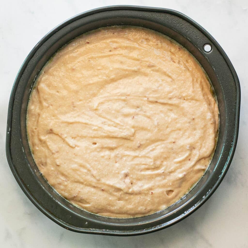 strawberry cake batter in a round cake pan