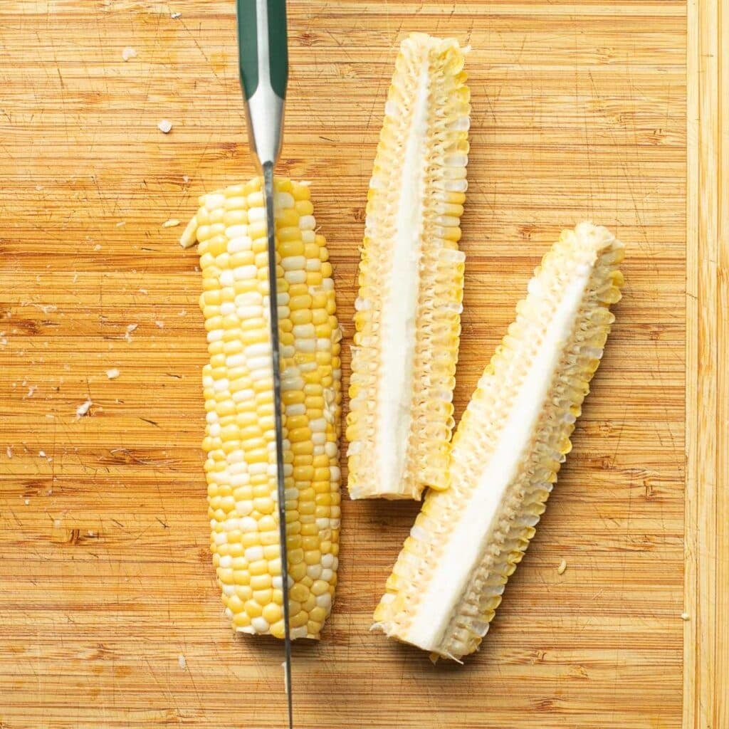 an ear of corn being cut into long strips