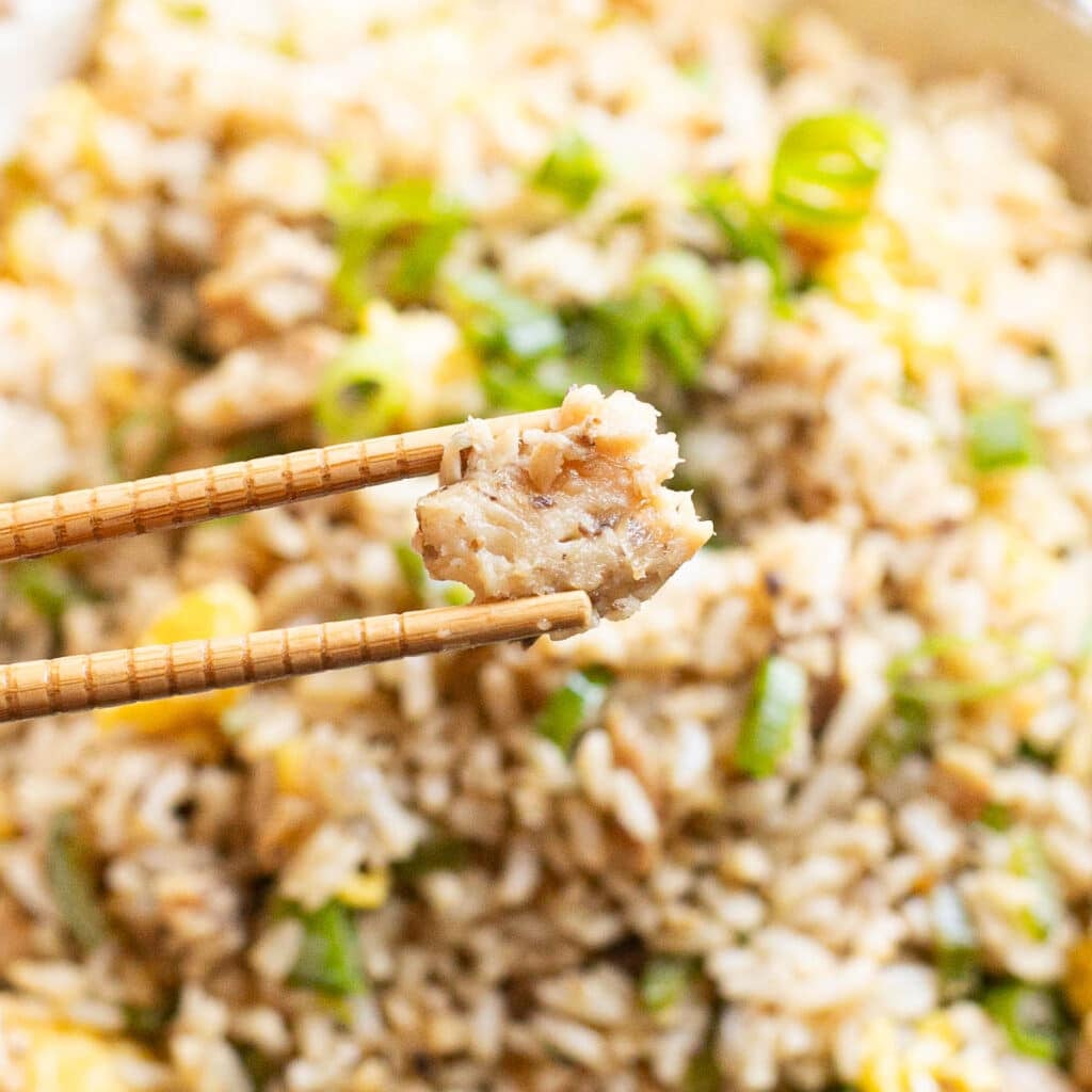 chopsticks holding a piece of a sardine