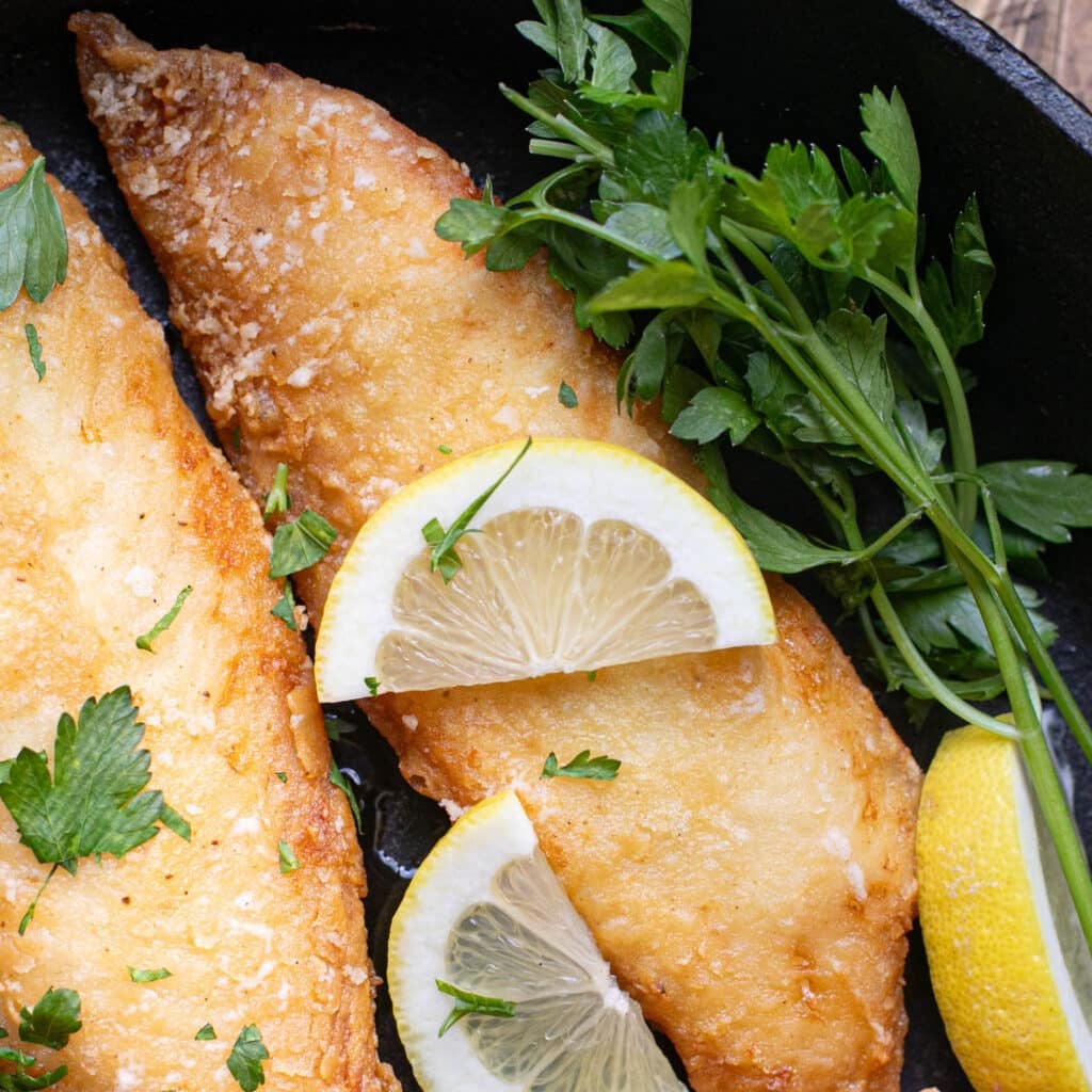 fried tilapia topped with lemons and parsley