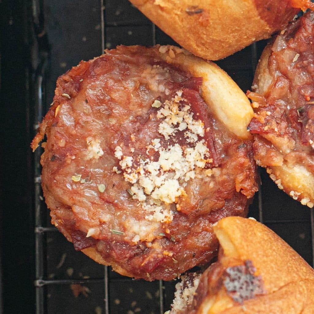 close up view of a pizza muffin topped with Parmesan cheese