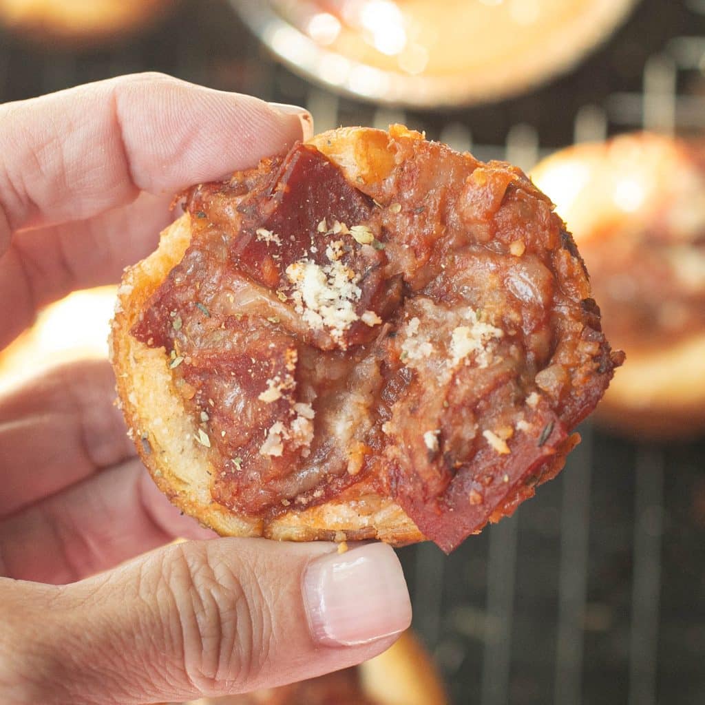 a hand holding a pizza muffin