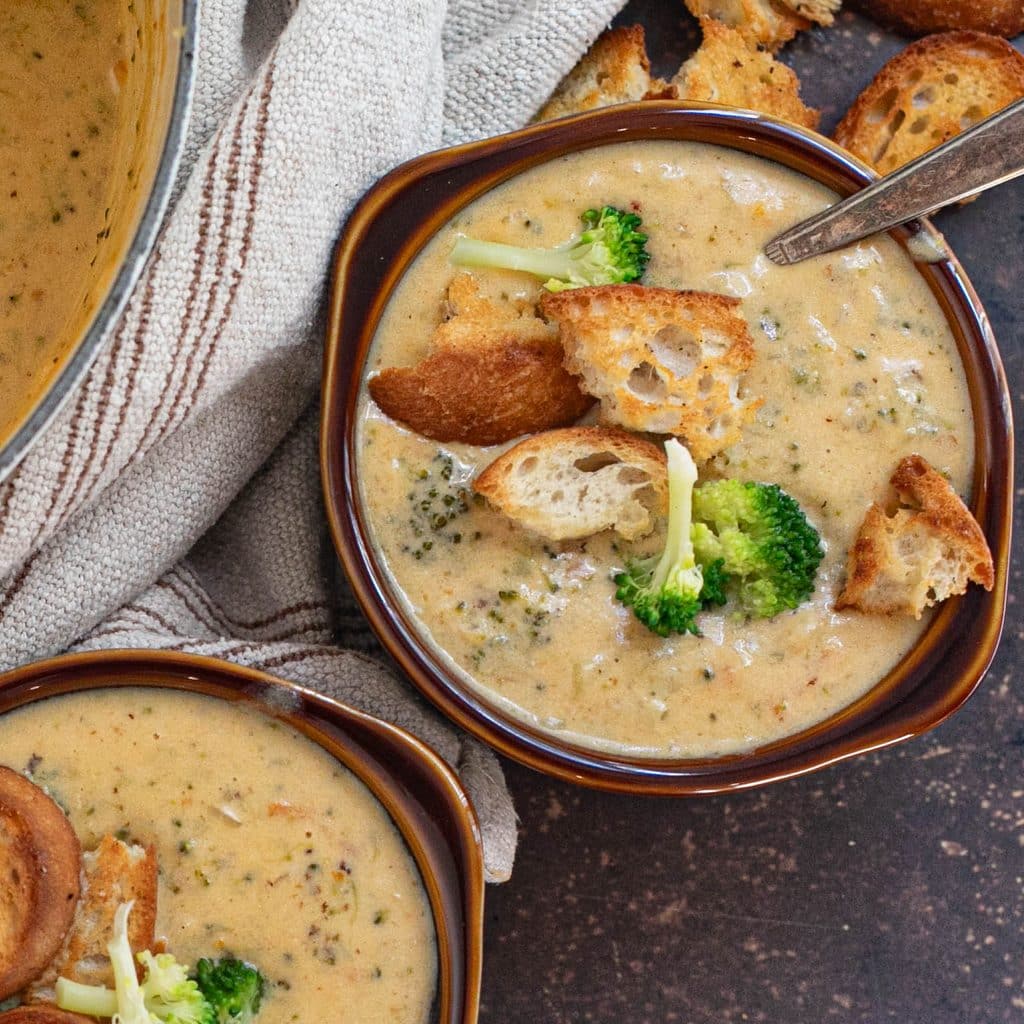 a crock of broccoli cheddar soup topped with homemade croutons