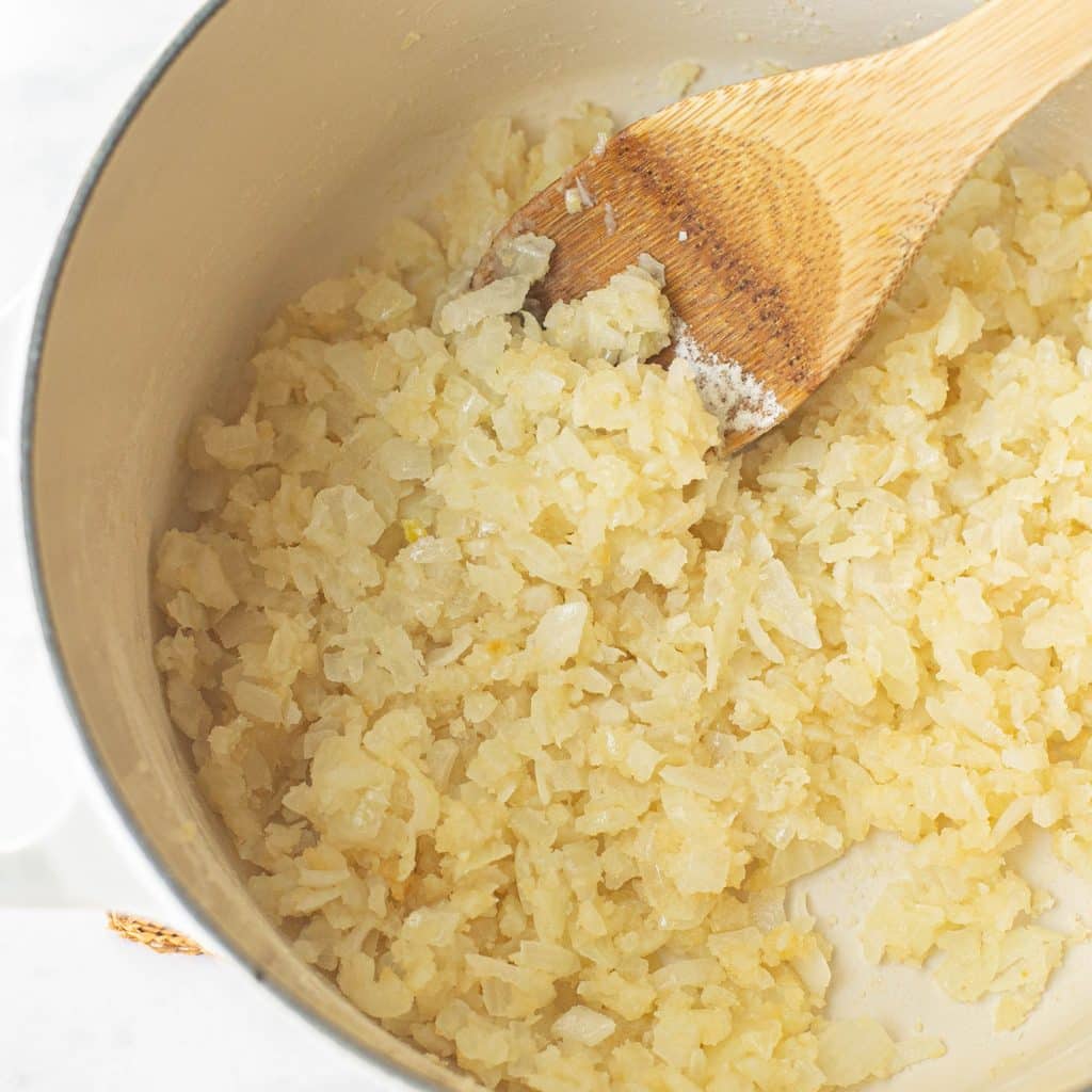 diced onions cooking in a Dutch oven