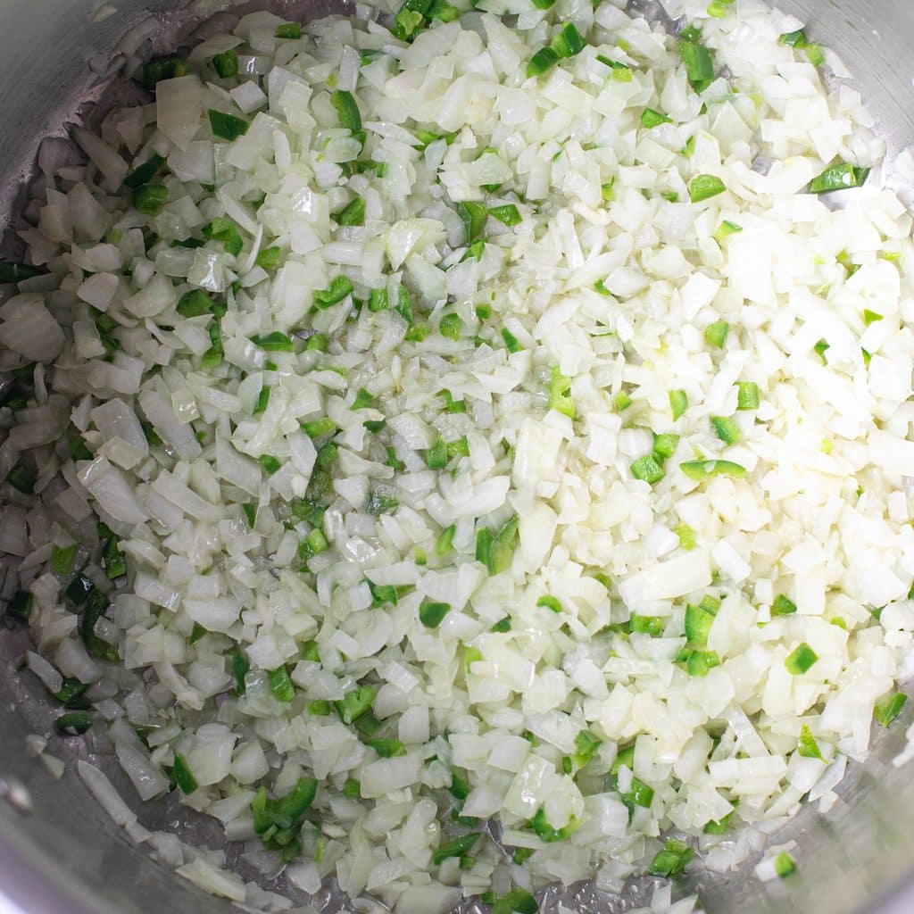 diced onions and jalapeno peppers cooking in a stockpot