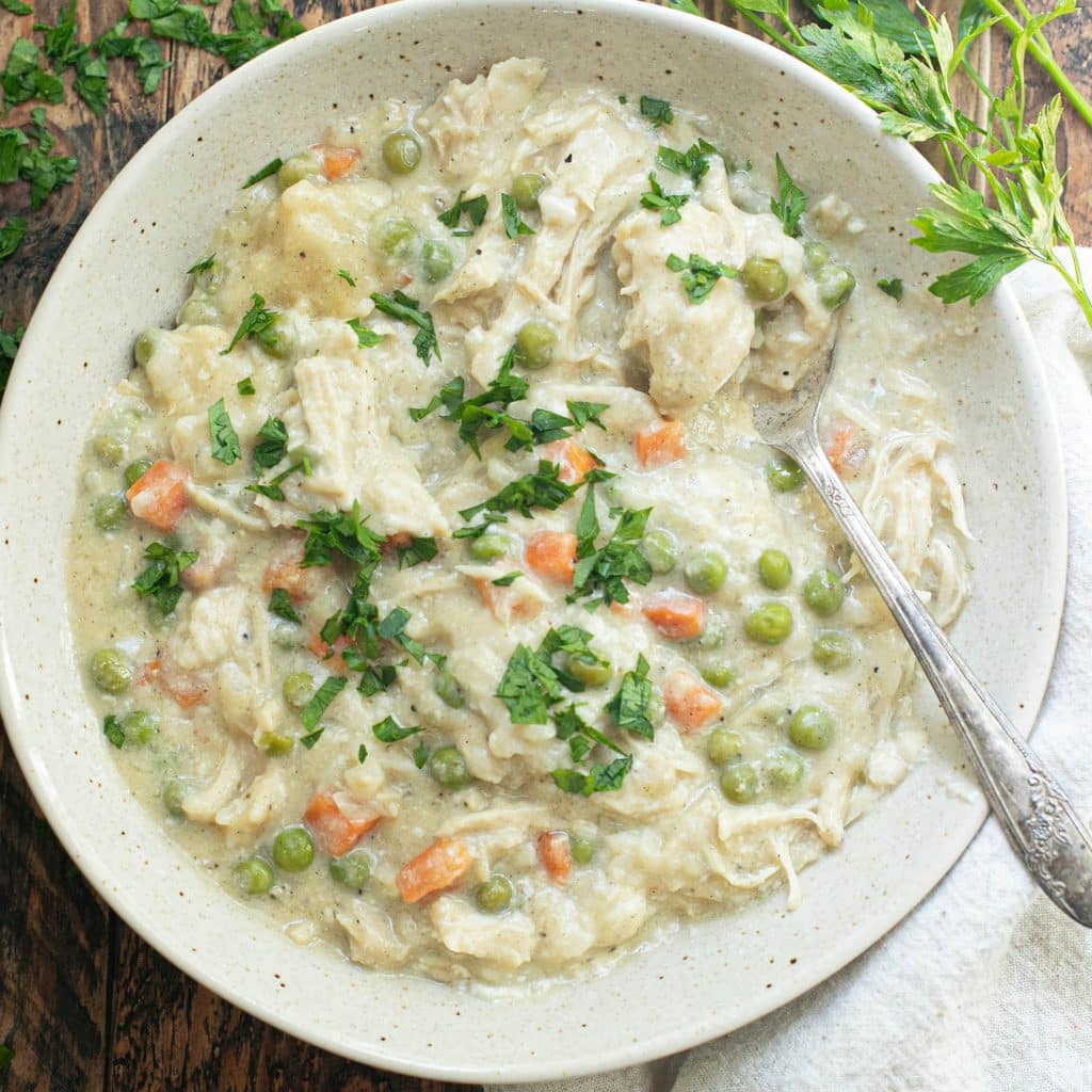 crockpot chicken and dumplings in a cream colored bowl