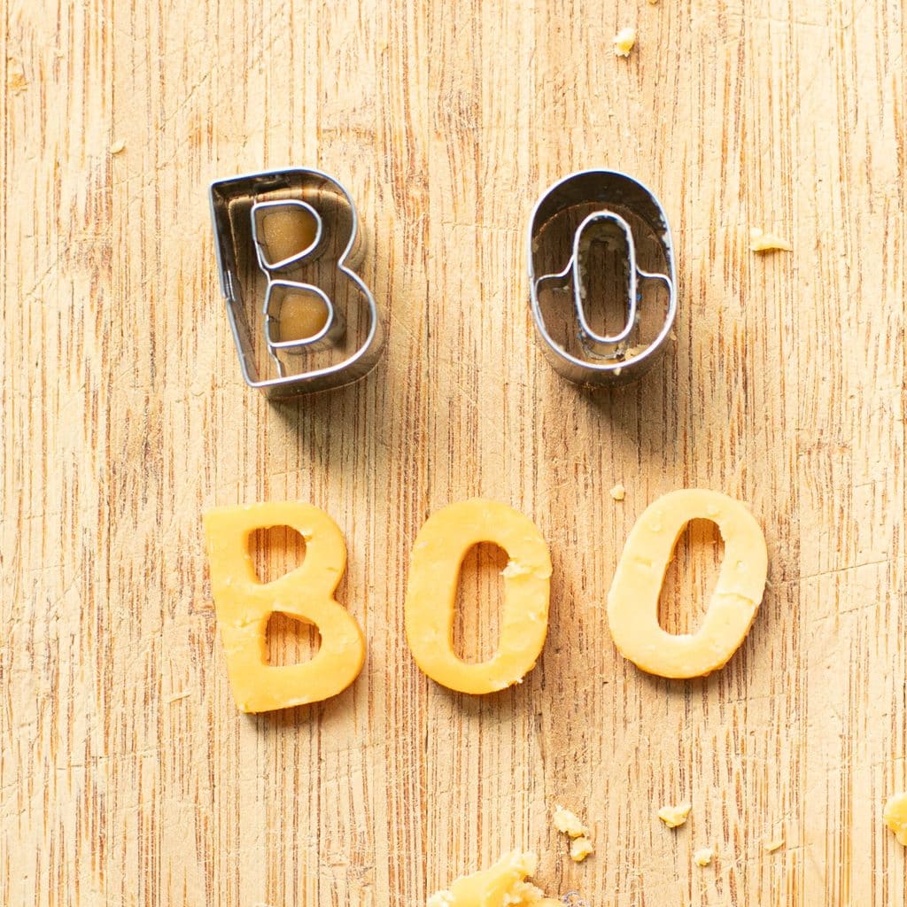 mini cookie cutters and the word BOO cut out of cheddar cheese