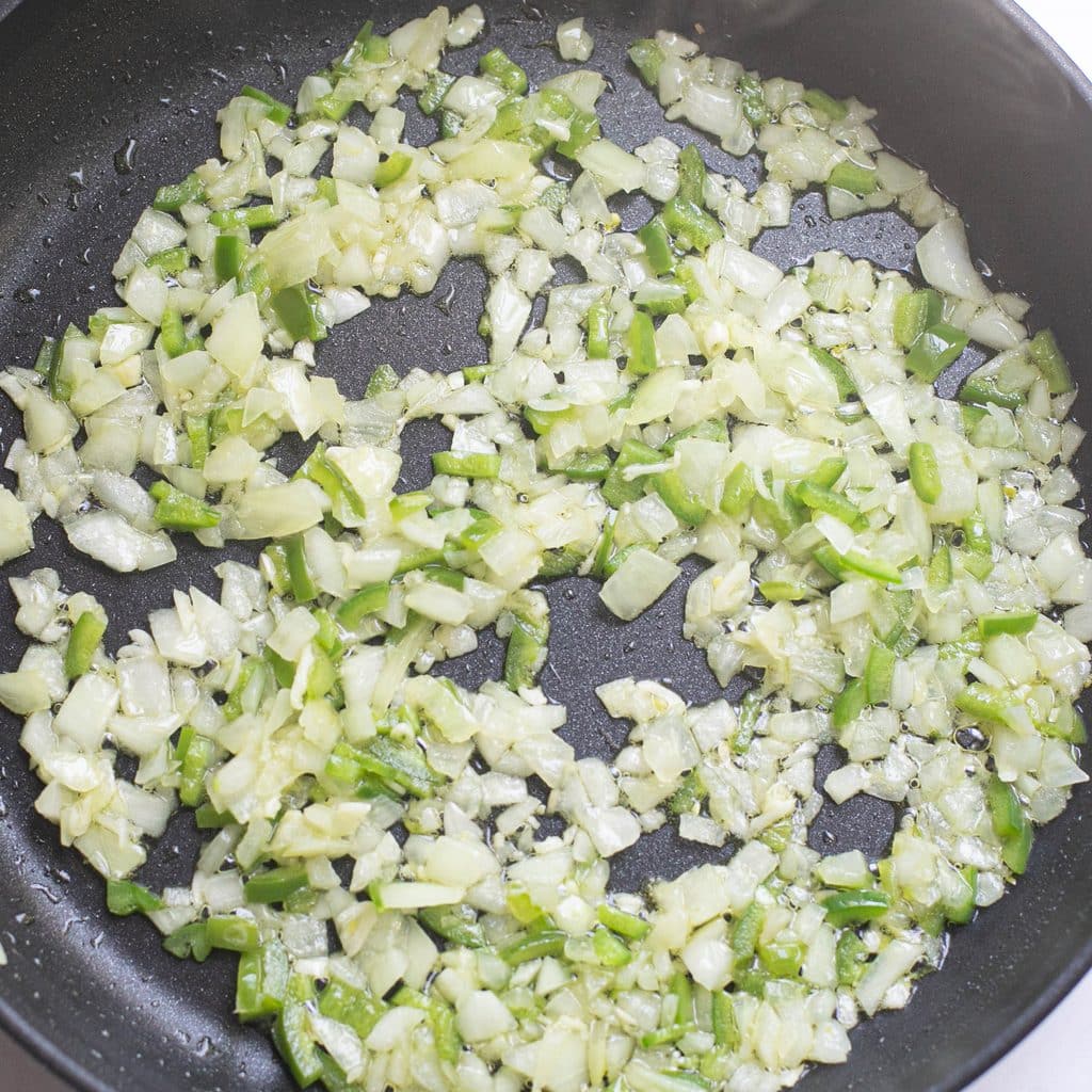 chopped onions and jalapeno peppers cooking in a pan