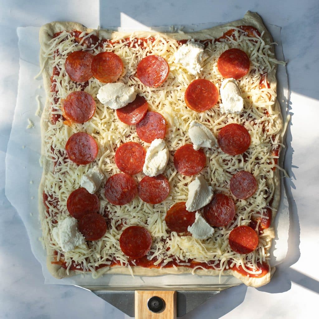 pepperoni pizza on a pizza peel before baking