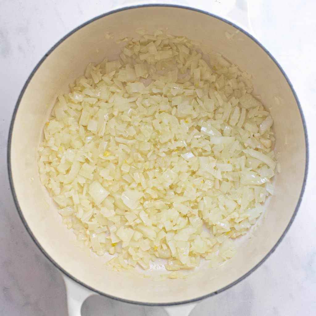 diced onions cooking in a Dutch oven