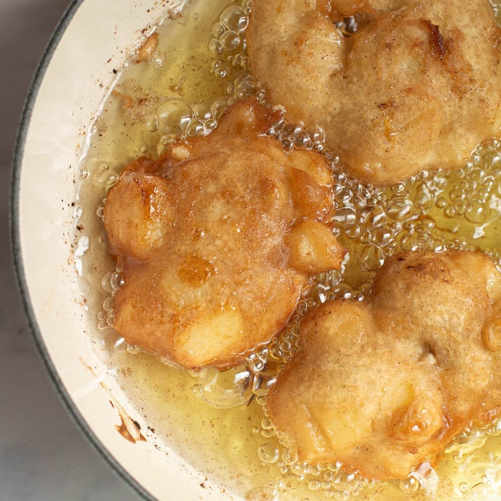 apple fritters frying in oil