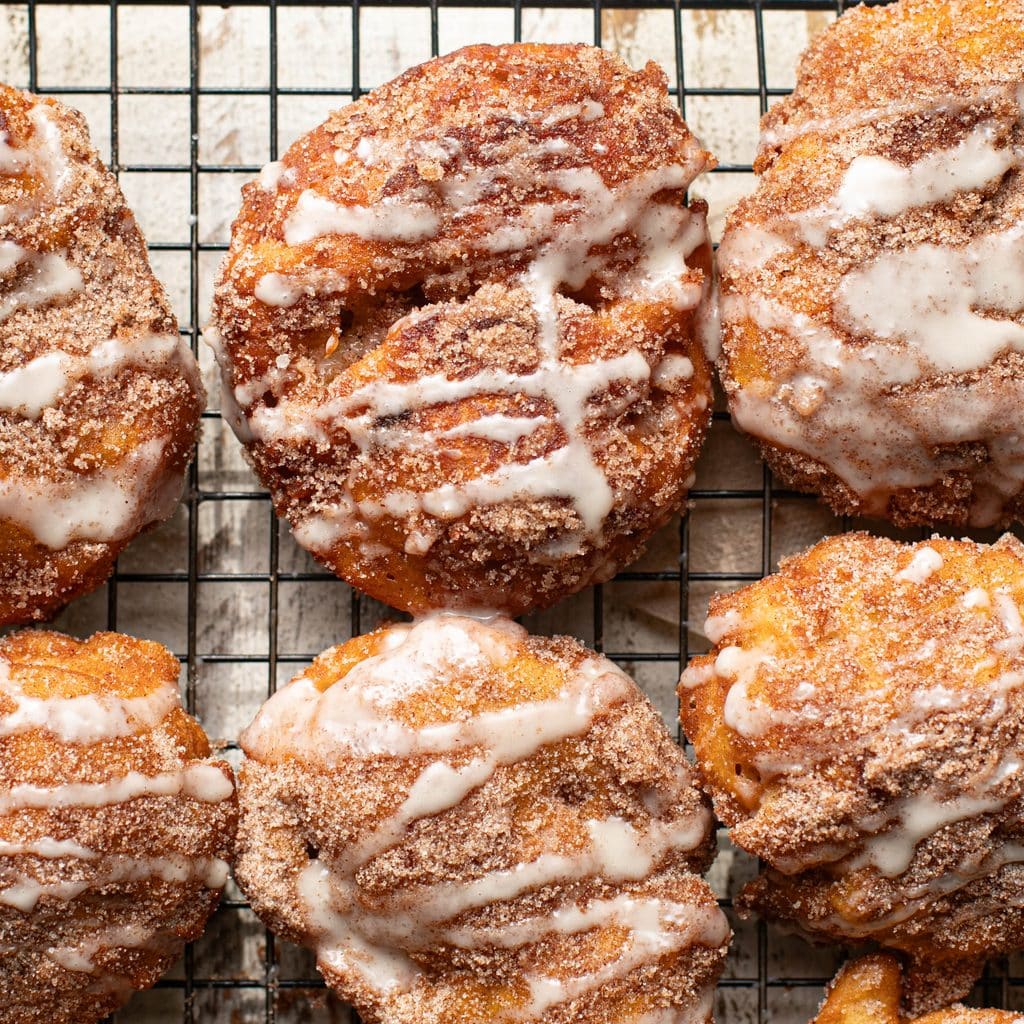 apple fritters with vanilla glaze on a wire rack