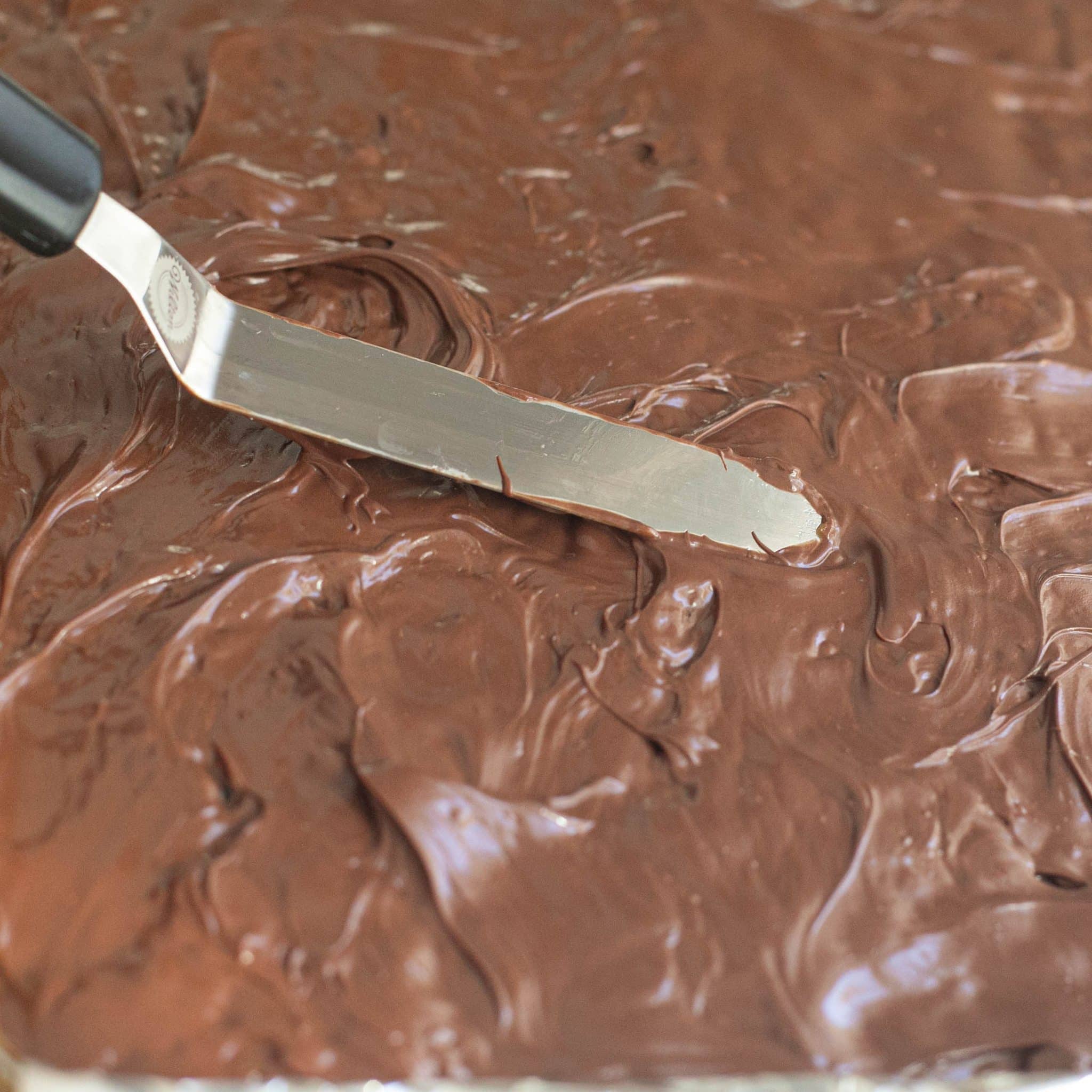 an offset spatula spreading chocolate