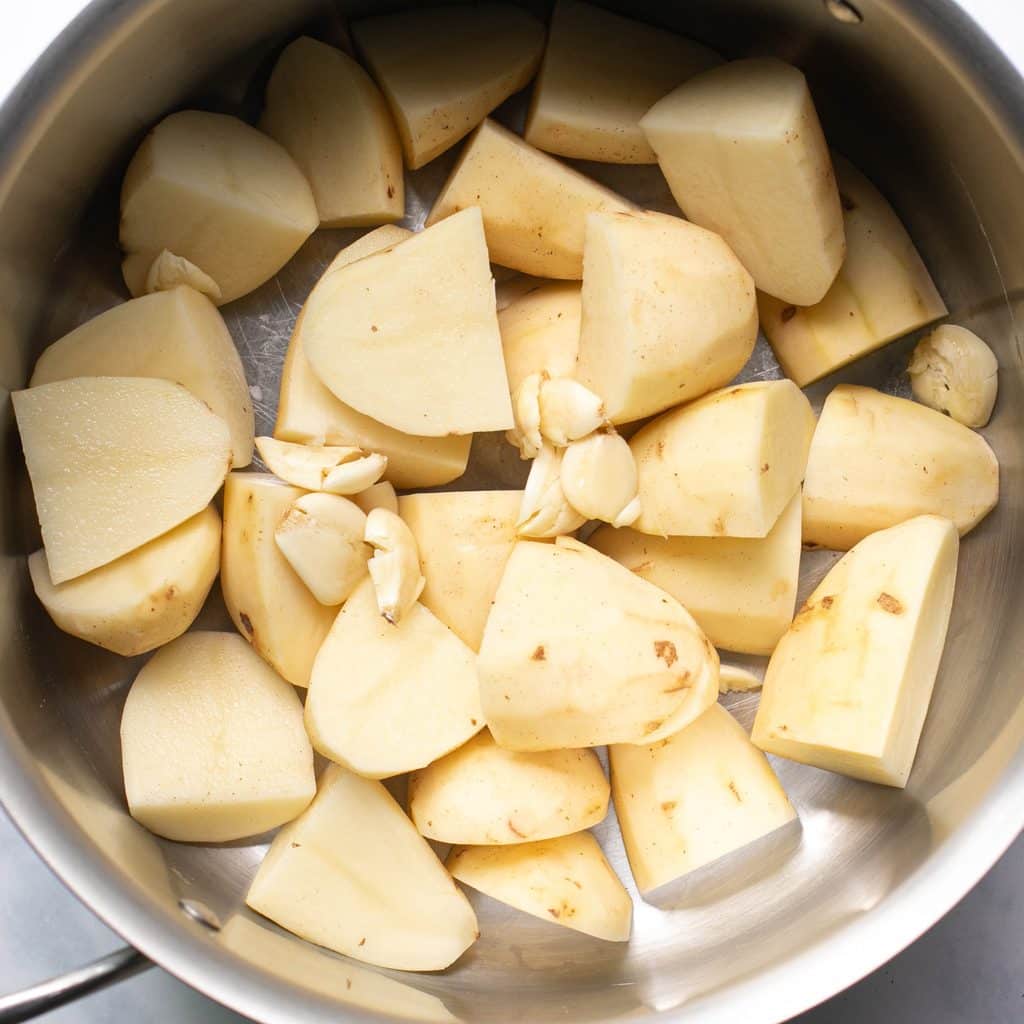 quartered and peeled potatoes and garlic cloves in a large pot