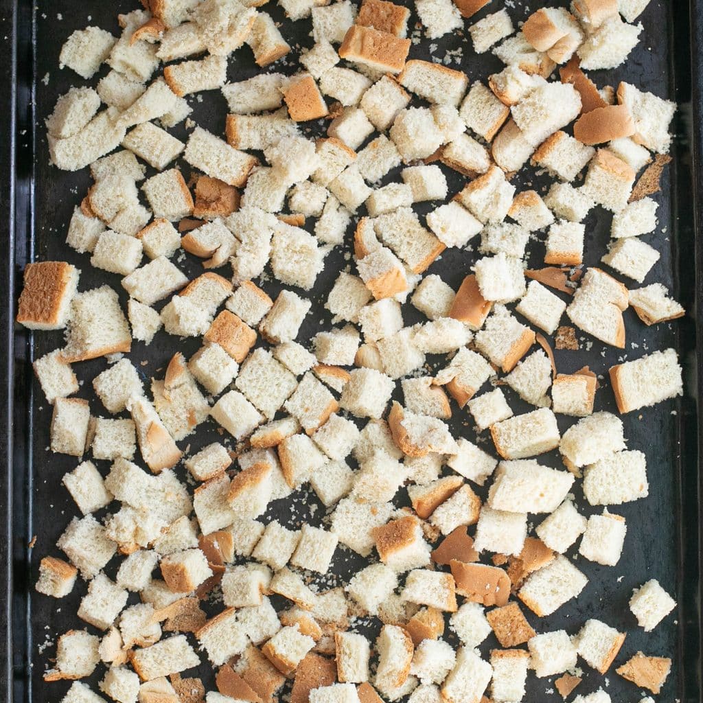bread cubes drying out on a baking sheet