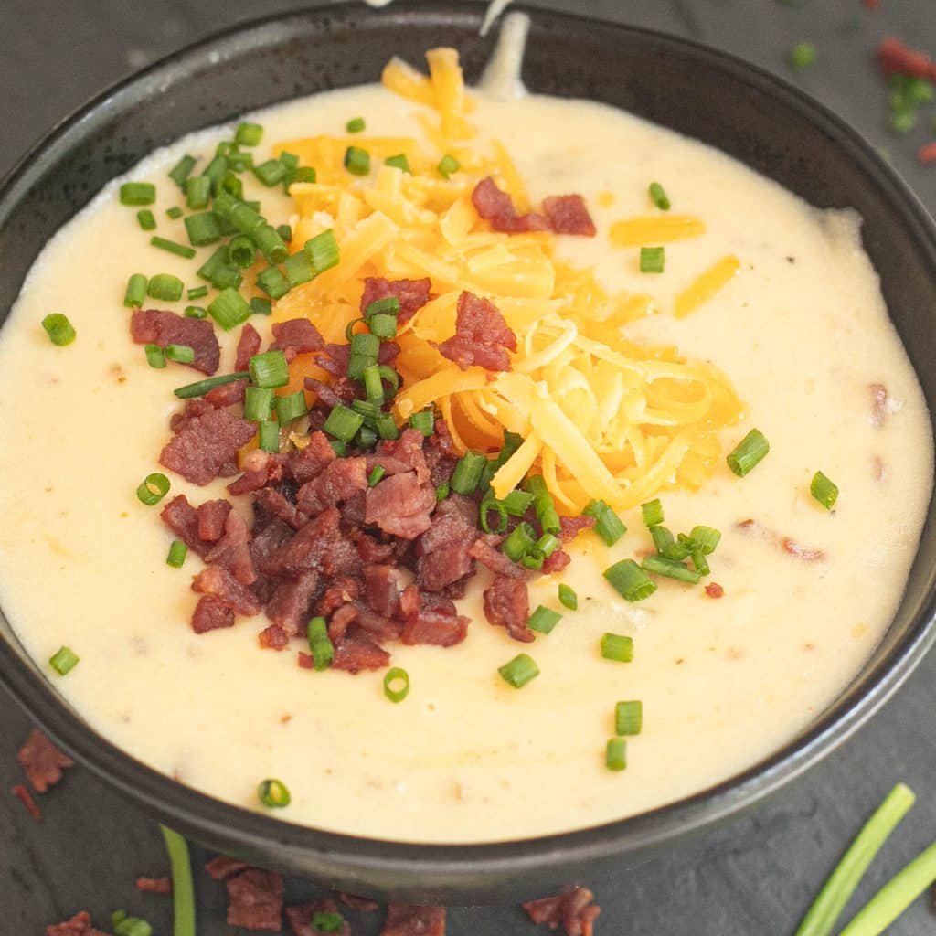 loaded potato soup topped with chives, bacon bits and grated cheese