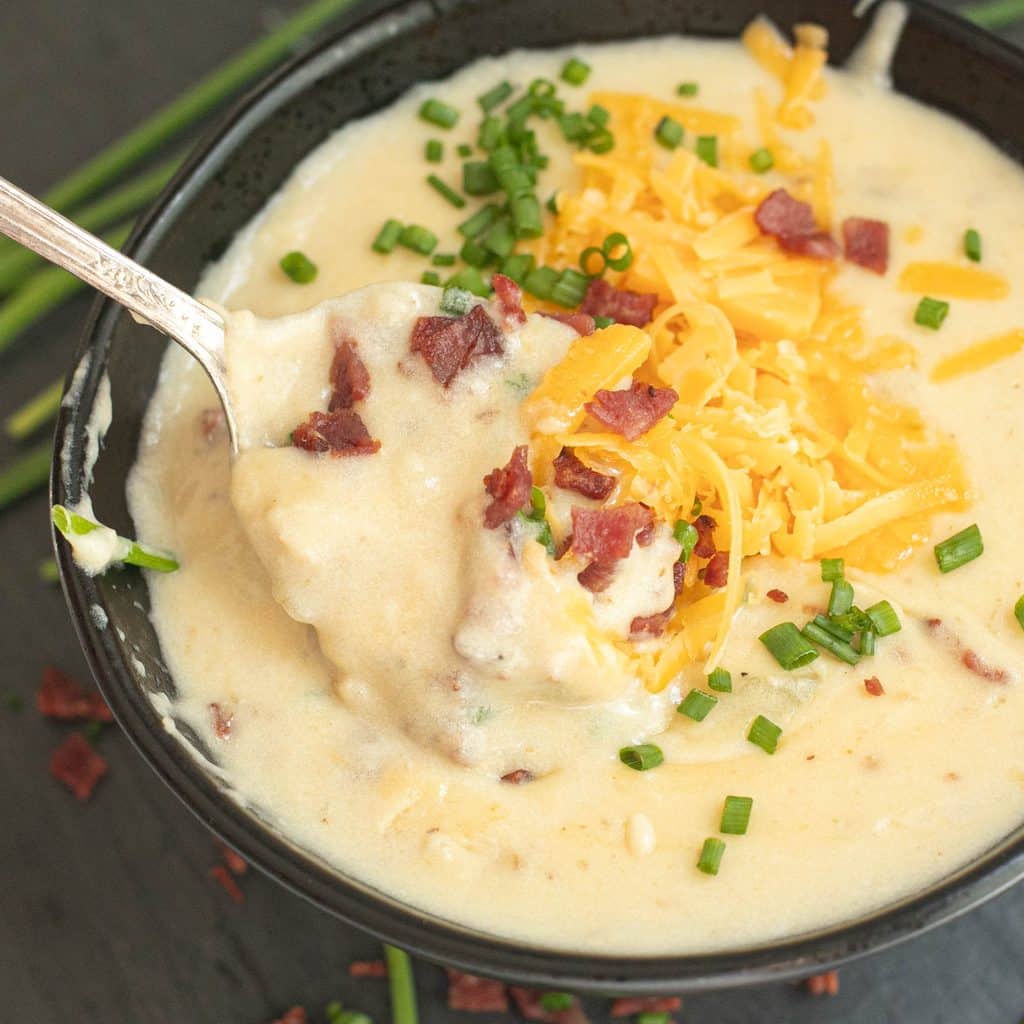 a spoon in a bowl of loaded baked potato soup