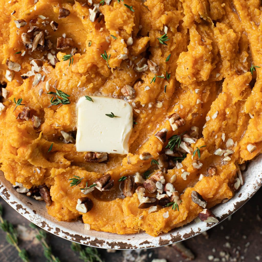 a pat of butter melting on top of mashed sweet potatoes