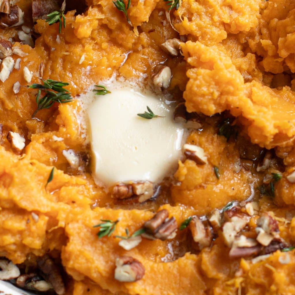 a pat of butter melting on top of mashed sweet potatoes