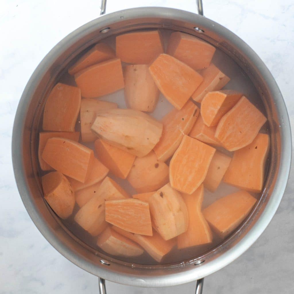 peeled and quartered sweet potatoes covered with water in a large pot