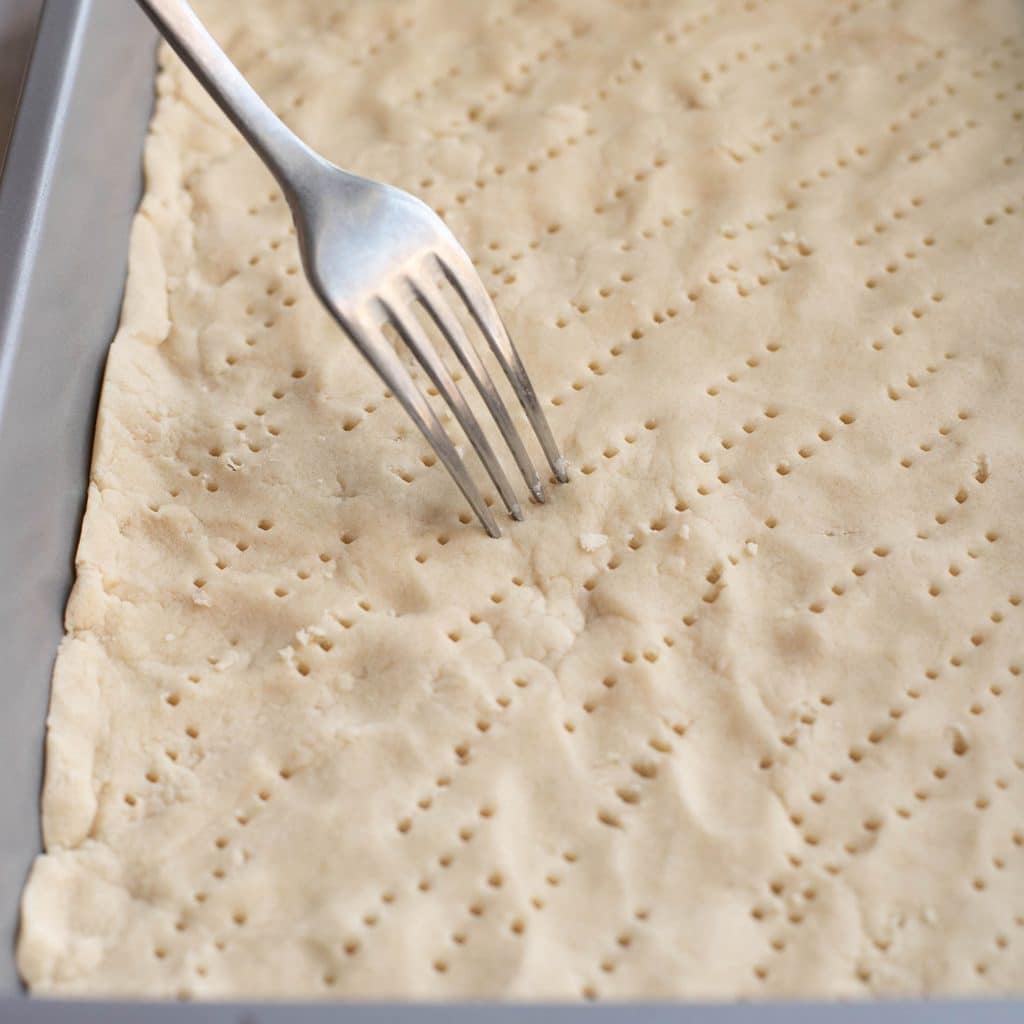 a fork piercing the surface of shortbread before baking