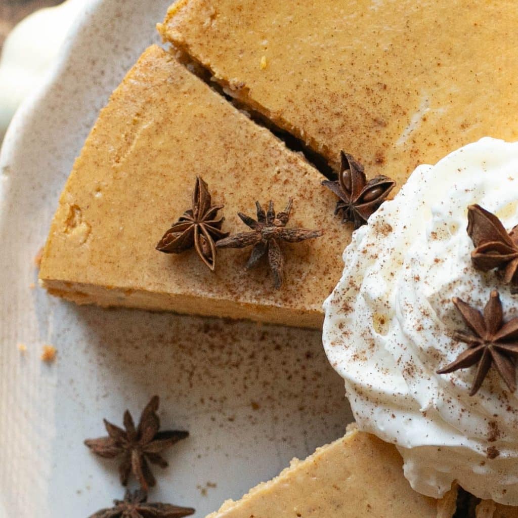 a slice of pumpkin cheesecake garnished with star anise