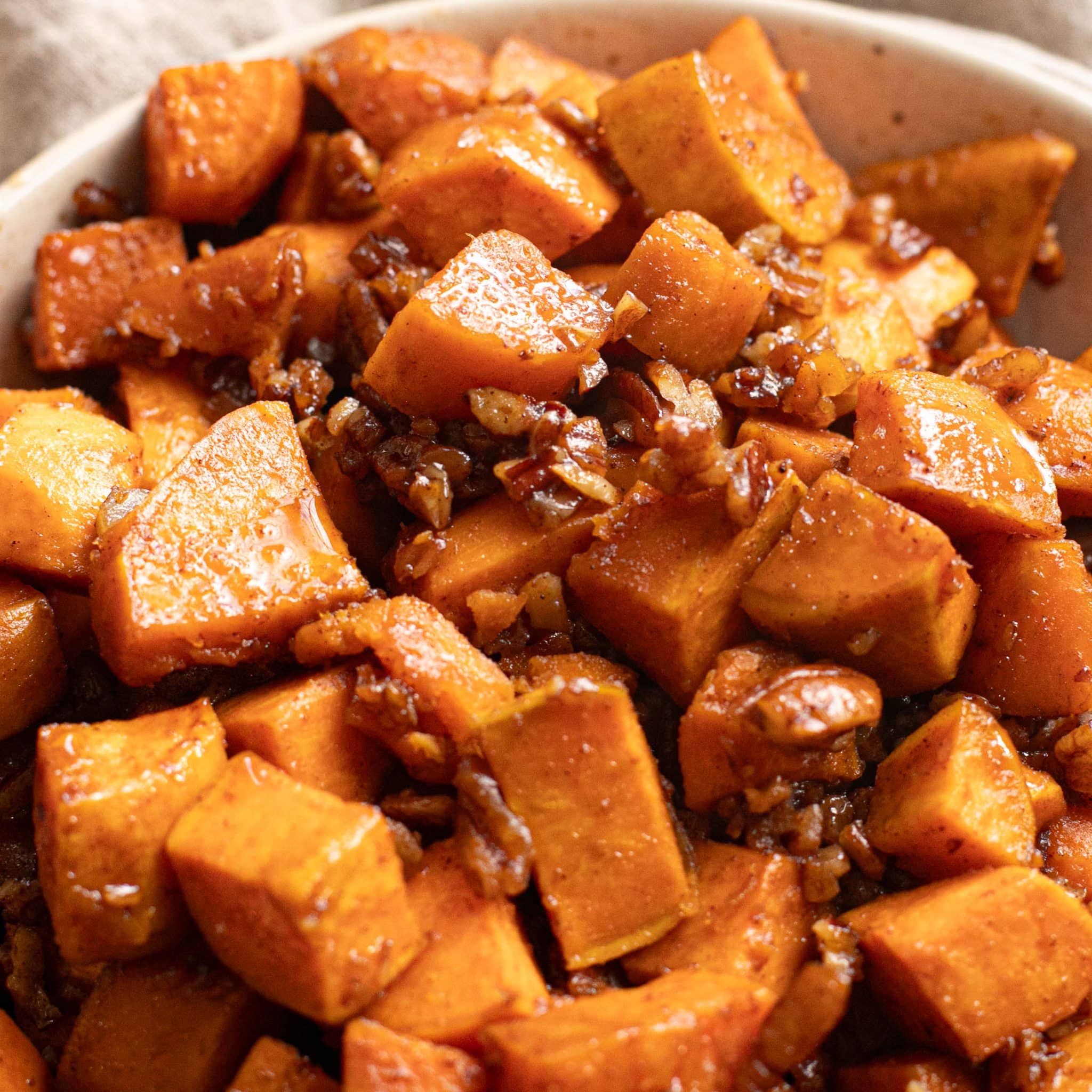 close up view of roasted sweet potatoes with chopped pecans