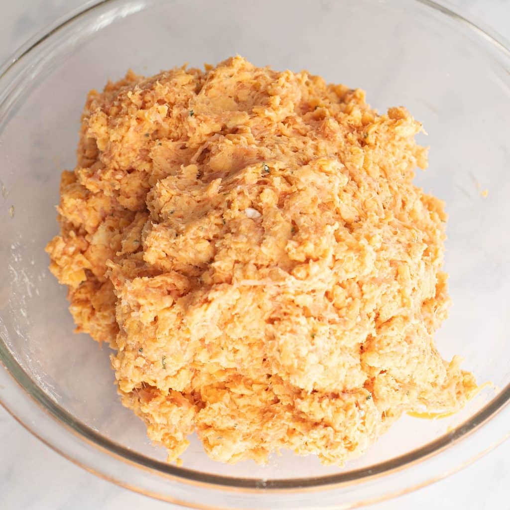 Bisquick sausage balls mixture in a glass mixing bowl