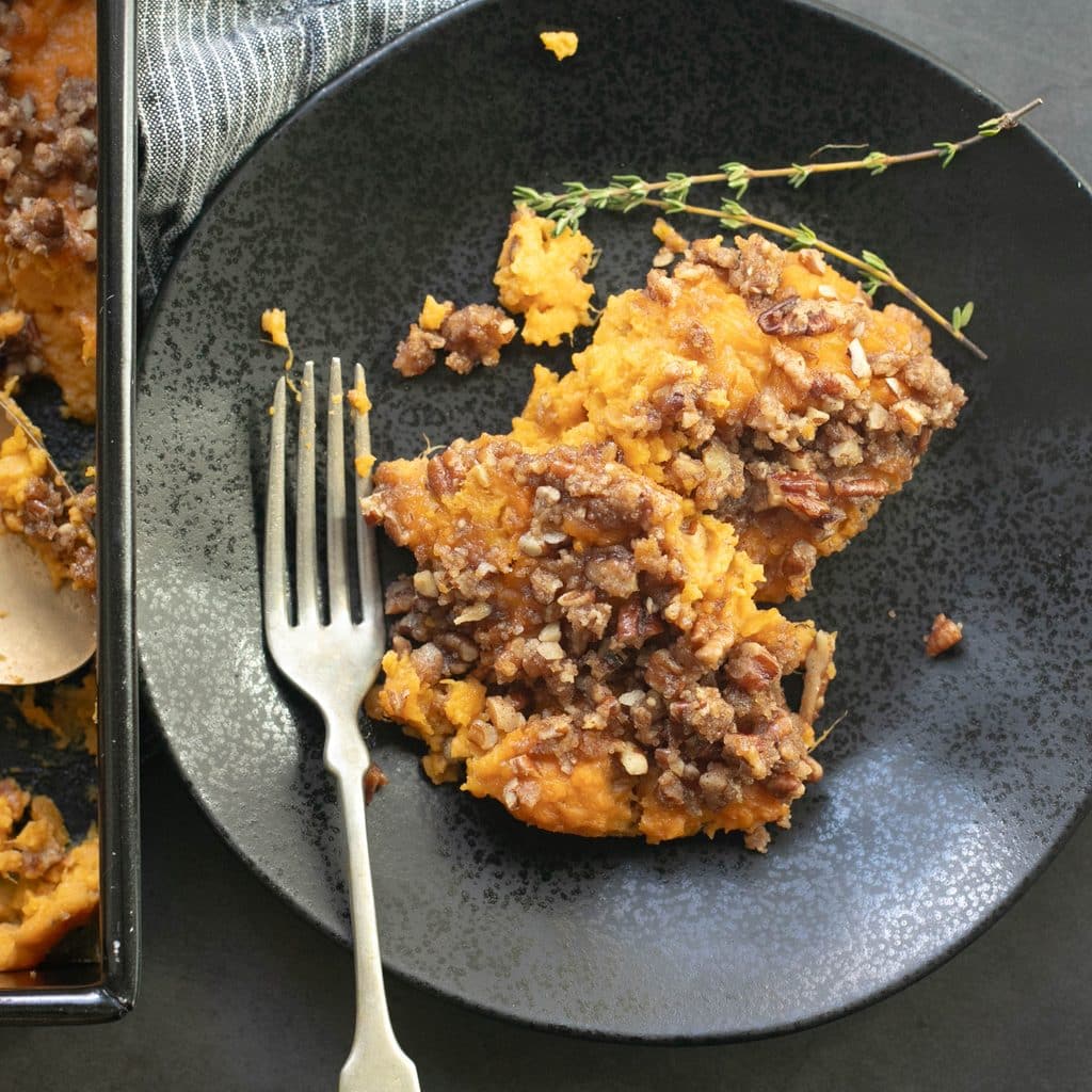 a serving of sweet potato casserole on a black plate