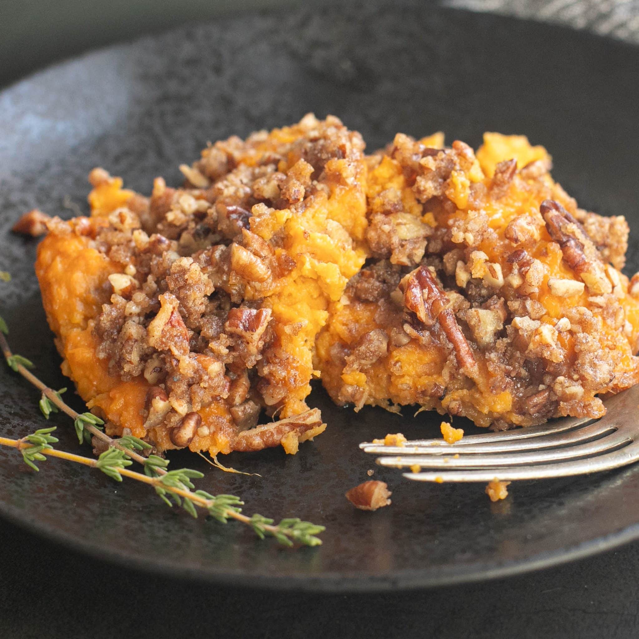 a serving of sweet potato casserole on a black plate