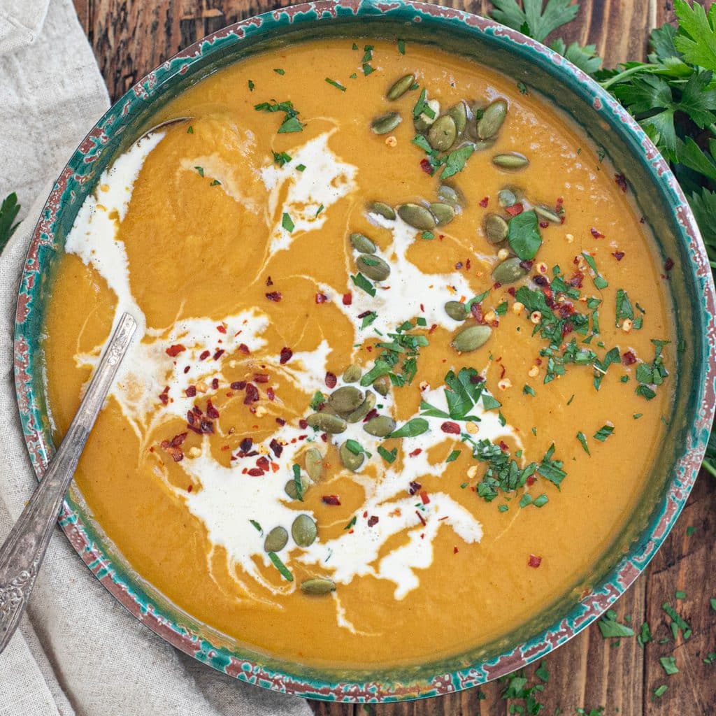 sweet potato soup topped with crushed red pepper, cream and chopped parsley
