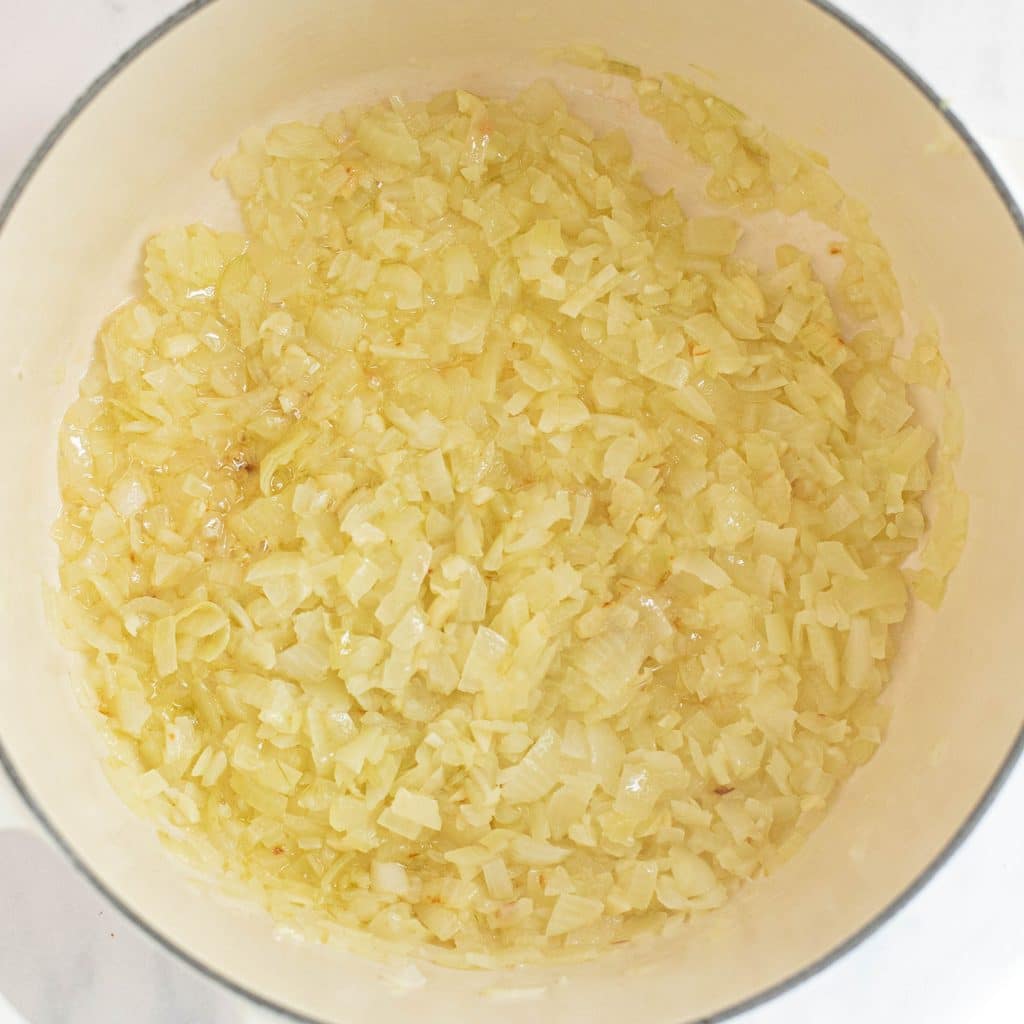 diced onions cooking in a Dutch oven
