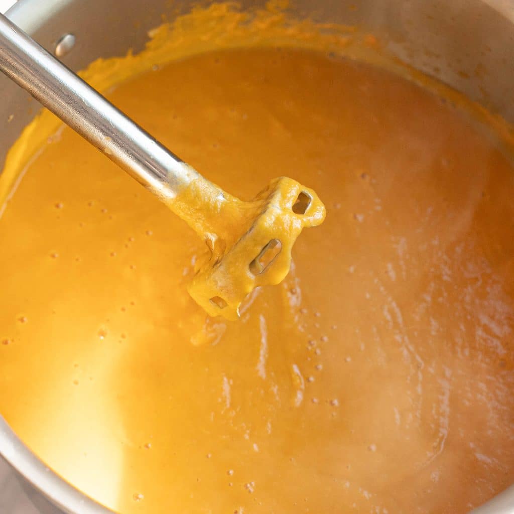 an immersion blender pureeing sweet potatoes