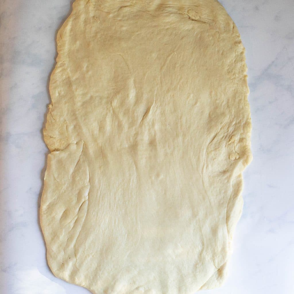 bread dough rolled out into a large rectangle
