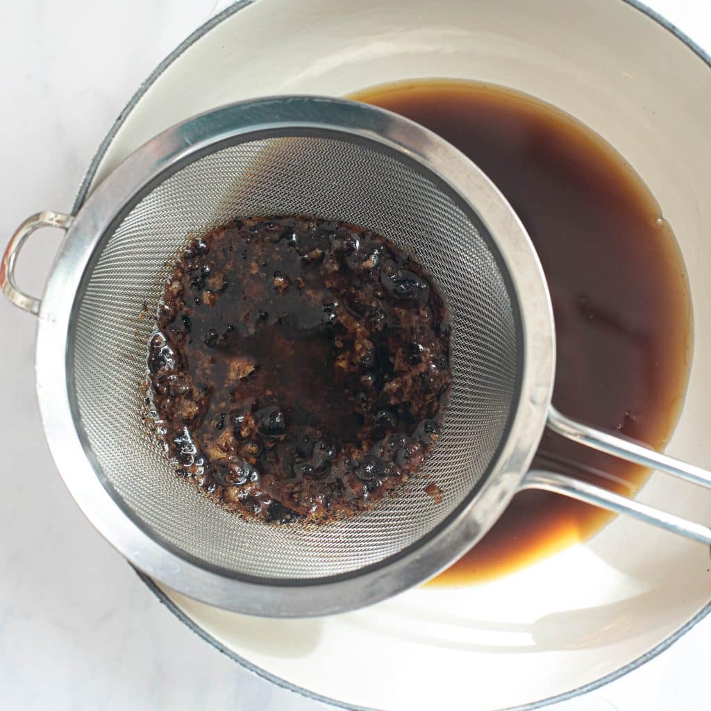 pan drippings in a mesh strainer