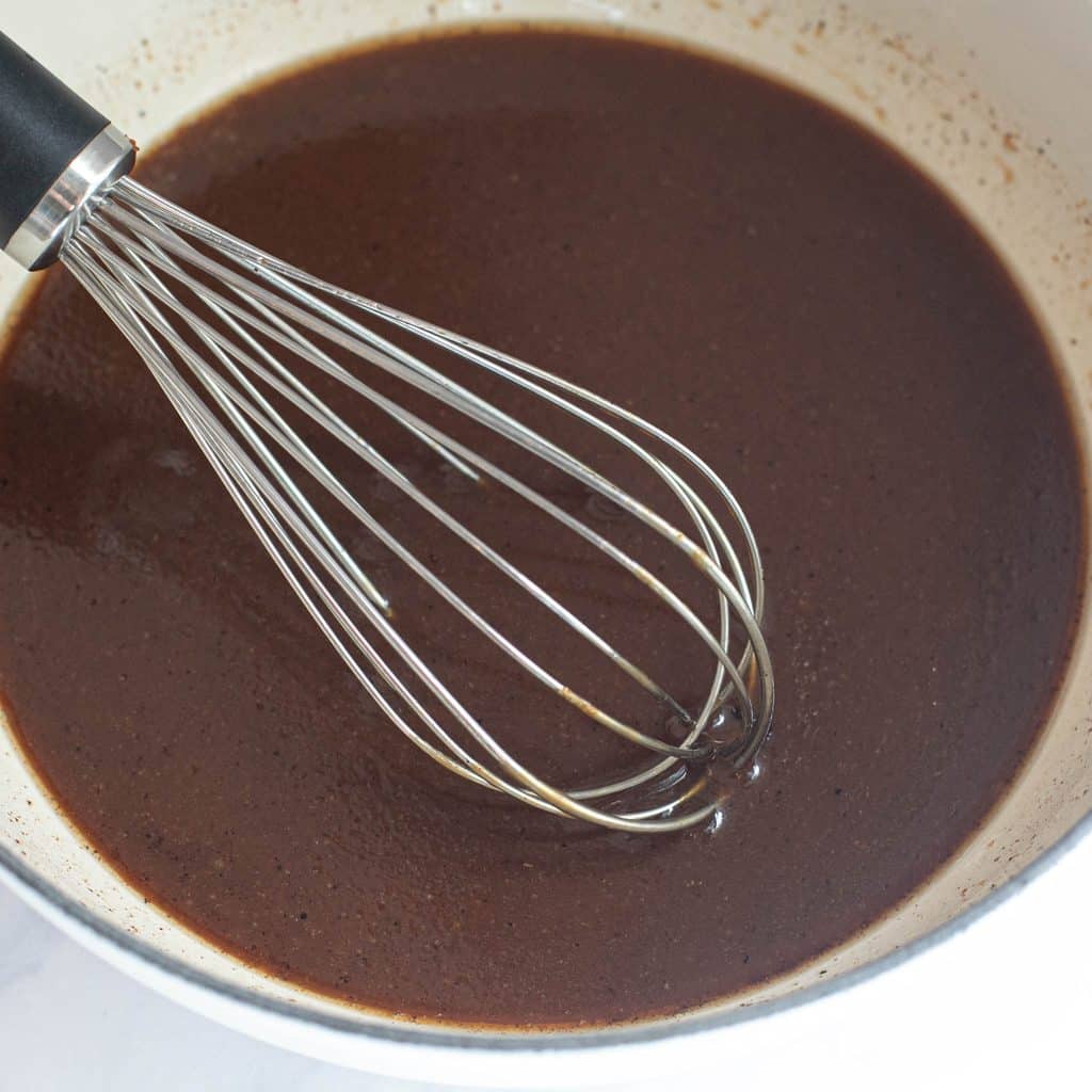 turkey gravy with a wire whisk in a pot