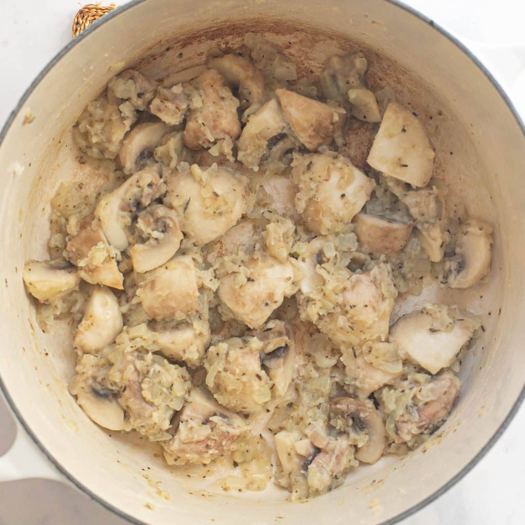 onions and mushrooms cooking in a Dutch oven